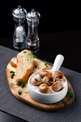 Escargots de Bourgogne Snails with herbs butter, in traditional ceramic pan with parsley sauce