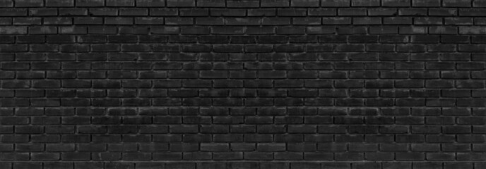 Old black messy exterior brick wall wide panoramic texture. Dark gray aged masonry. Grungy brickwork widescreen backdrop. Abstract grunge industrial background