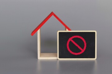 Toy house and red prohibition sign. Restrictions ban on construction. Building restrictions