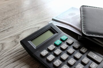 Calculator, wallet and money on wooden table with copy space. Business and finance concept