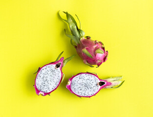 Dragon Fruit, pitahaya: whole fruit and cut on a colorful yellow background, top view. Tropical fruits.