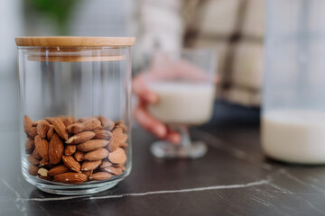Almonds and almond milk and glass on kitchen counter. Healthy vegan product concept.