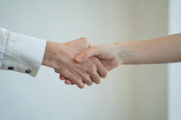 Businessmen shake hands to each other after successful meeting on white background. People come to agreement at work in office room close view