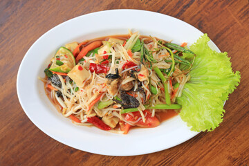 Papaya Salad (Som Tam Pa) the traditional Thai foods on wood table background. Most wanted popular food in Thailand.
