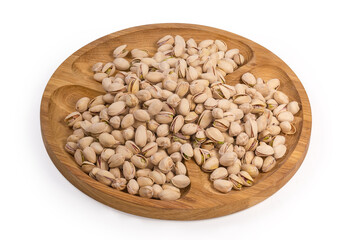 Roasted salted pistachio nuts on wooden dish on white background
