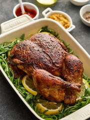 Grilled whole chicken with lemons.