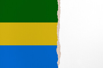 Half- ripped paper background in colors of national flag. Gabon