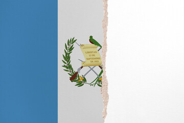 Half- ripped paper background in colors of national flag. Guatemala