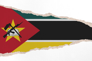 Ripped paper background in colors of national flag. Mozambique