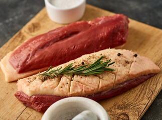Raw duck Breasts with skin set, with herbs and ingredients, on wooden board