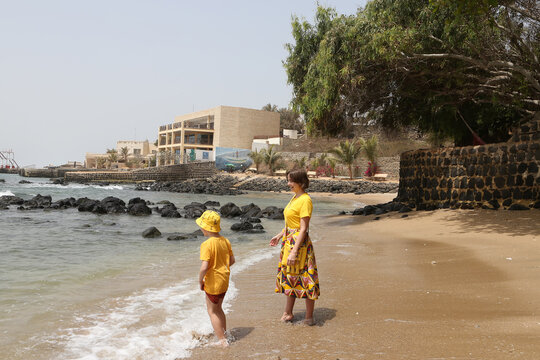 Tourist people, mother with son, woman and kid, child. Atlentic ocean on Ngor island, Senegal, Africa. Coast, coastline of Atlentic ocean. African nature, idyllic landscape, scenery. Tourism, travel