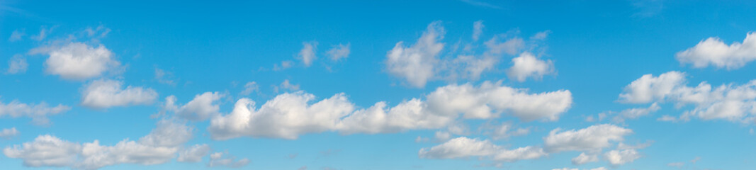 Banner with panoramic view over deep blue clean sky with illuminated clouds as a background. © neurobite