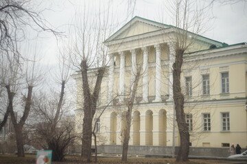 Full-color horizontal photo. An urban landscape with white building structures against a blue sky background.