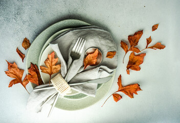 Overhead view of an autumnal place setting with dried autumn leaves