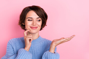 Portrait of adorable minded girl finger chin look curious arm hold empty space isolated on pink color background © deagreez
