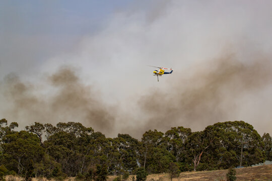 Bundoora, Australia - December 30, 2019: Bell 412 Helicopter Flying Against Plumes Of Smoke While Fighting Bush Fires In Victoria, Australia.