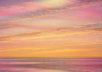 Fototapeta na wymiar pink sunset at sea water reflection sun light on gold yellow clouds sky nature background
