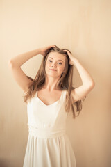 Fototapeta premium young girl with fingers in her hair, looking at camera and smiling