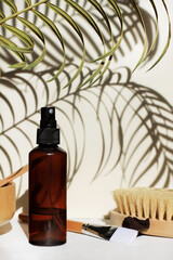 Beauty spa treatment, skin care cosmetic product in dark spray bottle, bath toiletries, tropical palm leaf shadow, herbal botanical beauty remedy,sunlight shadows wall background beige tones, vertical