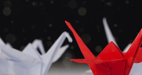  Image of spots falling over origami red and white birds on black background © vectorfusionart