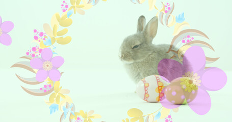 Image of easter eggs and easter bunny with spinning flowers on green background