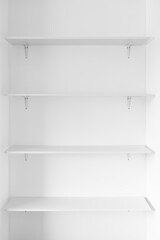 minimalist white wall with white shelves in a niche, modern interior design and simple home improvements