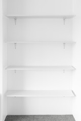 minimalist white wall with white shelves in a niche, modern interior design and simple home improvements