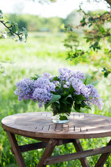 bouquet of lilacs on the table in the summer garden