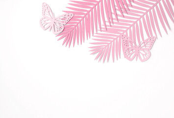 Fototapeta na wymiar Pastel Pink Tropical Leaves on a White Background. Simple Modern Composition with Paper Cut Palm Tree Leaves and Butterfies ideal for Banner, Card, Greetings. Top-Down View. No tex.