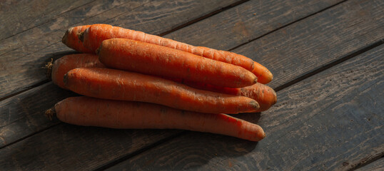 Carrots lie on wooden boards. Concept: market, vegetables, carrots