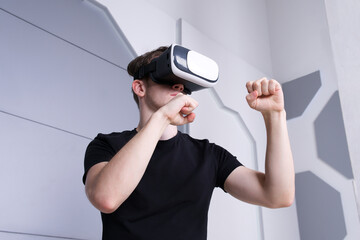 Portrait of happy young handsome man guy using, wearing a modern device virtual reality headset mask or 3D, AR, VR glasses, playing the game, fighting. People and technology metaverse concept.