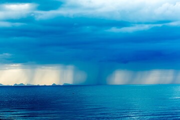 Rain clouds over ocean with rays of light