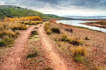 Camino junto al embalse de Finisterre un día nublado. Toledo.
