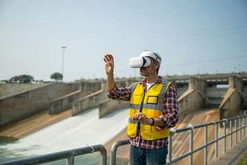 Portrait of engineer wearing yellow vest and white helmet using augmented reality application in...