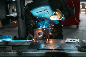 Industrial welder worker welding steel or iron in a factory