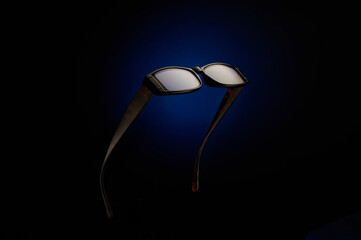 sunglasses on black and blue background.