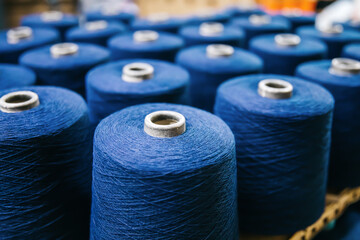 Cotton yarns or threads on spool tube bobbins at cotton yarn factory. - Powered by Adobe