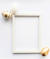 Gold white eggs on a white background with space for copy space for text in a frame. Minimal concept. View from above. Easter card, soft selective focus.