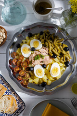 Potato salad with tuna, boiled egg, green beans, cherry tomato and olives with vinaigrette sauce. Typical Spanish and Mediterranean salad in summer
