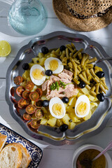 Potato salad with tuna, boiled egg, green beans, cherry tomato and olives with vinaigrette sauce. Typical Spanish and Mediterranean salad in summer