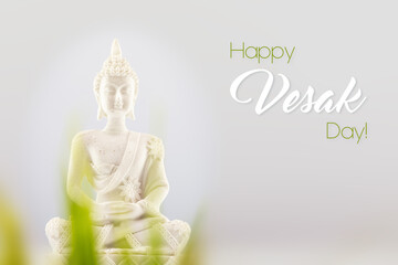 Vesak, Buddha Day holiday card with white Buddha statue on a neutral light gray background with inscription happy Vesak day. Soft image and soft focus style