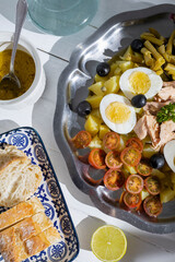 Potato salad with tuna, boiled egg, green beans, cherry tomato and olives with vinaigrette sauce. Typical Spanish and Mediterranean salad in summer