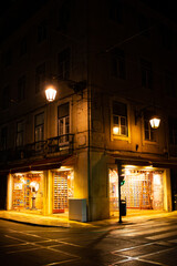 Beleuchtetes Geschäft an einer Straßenecke nachts in Lissabon