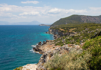 Fototapeta na wymiar View of the coastline and cliffs in the Mediterranean sea in sunny day with blue sky, Greece 