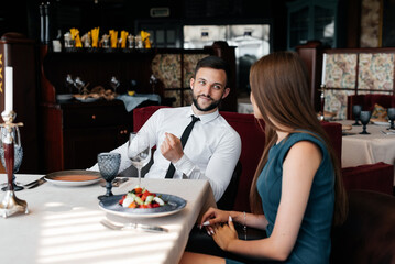 A man and a woman in love spend a romantic date in a gourmet restaurant. Romance, and a meeting of lovers in a restaurant.
