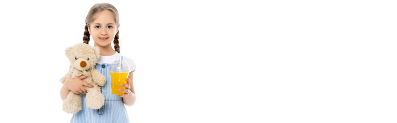 smiling girl holding teddy bear and orange juice isolated on white, banner.