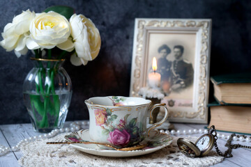 Vintage still life, a cup of tea, a clock, old books and other old things.