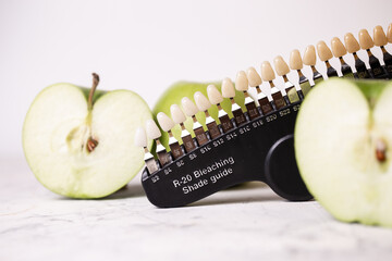 Color scale of teeth cosmetic dentistry. Scale and green apples