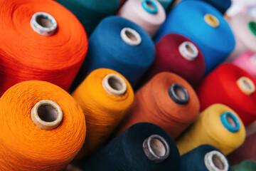 Colorful cotton yarns or threads on spool tube bobbins at cotton yarn factory.