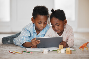 Getting the help they need from educational apps. Shot of a little boy and girl using a digital tablet together at home.